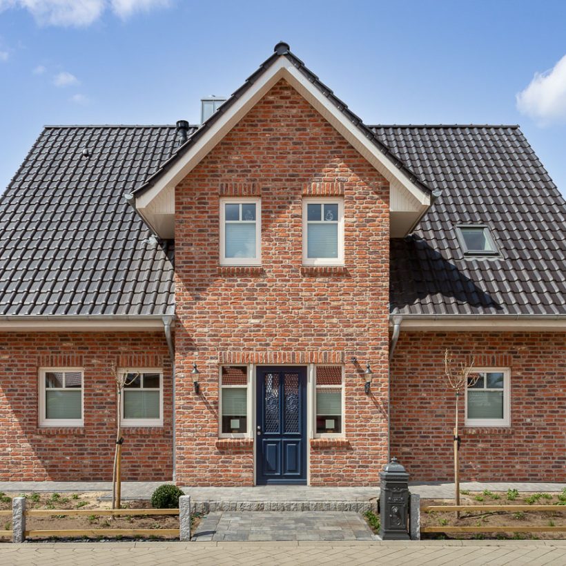 Vooraanzicht van een klinkerstenen huis met FD-dakpan W6v pin de kleur antraciet