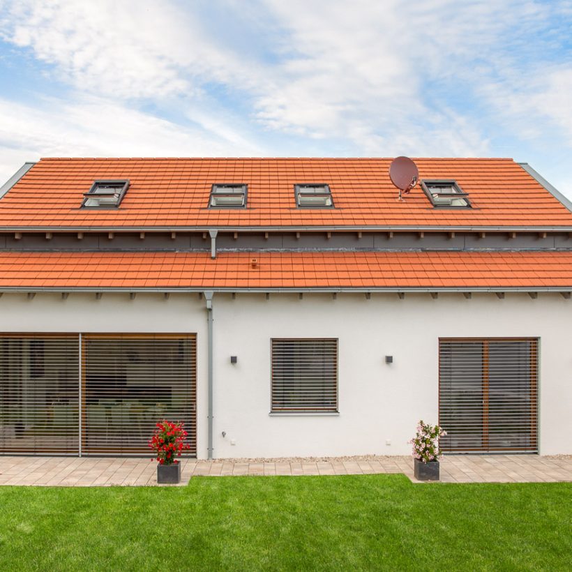 Vooraanzicht van een puristisch vrijstaand huis met Stylist vlakke dakpan in natuurrood