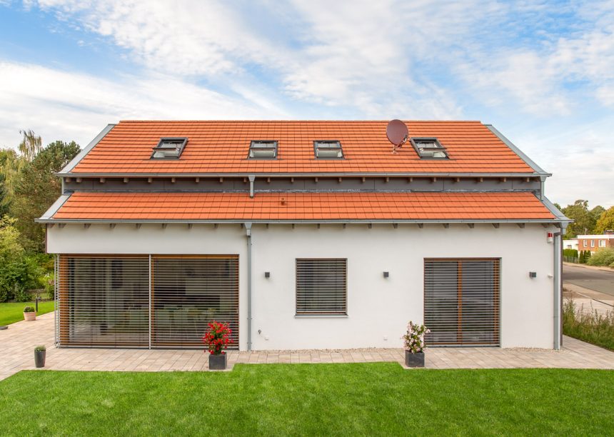 Vooraanzicht van een puristisch vrijstaand huis met Stylist vlakke dakpan in natuurrood