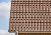 Vooraanzicht van een kapiteinswoning met FD-dakpan J11v in donkerbruin met details in baksteen.