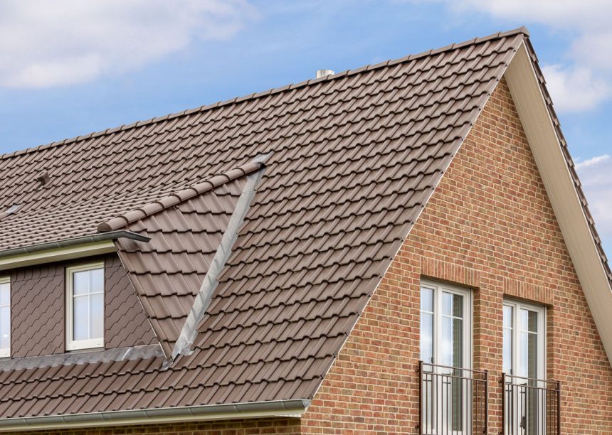 Vooraanzicht van een kapiteinswoning met FD-dakpan J11v in donkerbruin. De puntgevel met dakoverstek staat in het midden van de foto.