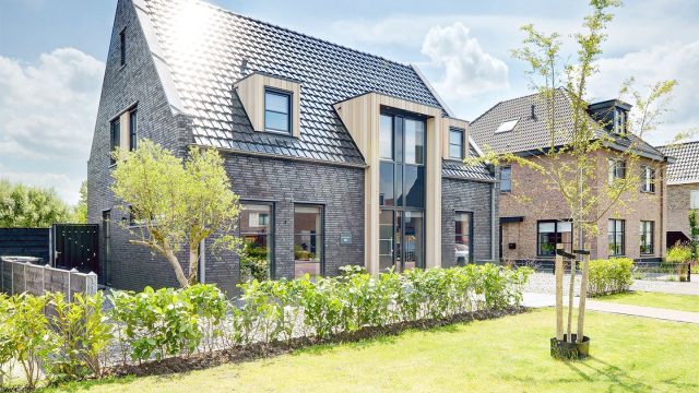 Moderne dakpan J160 in edelspacegrijs op een moderne klinkervilla. de hoekige J160 met zijn glinsterende oppervlak geeft het referentieobject in grijstinten een hoogwaardige glans.