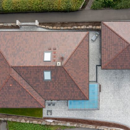 Zicht in vogelvlucht op schilddak met stylist in cottage.