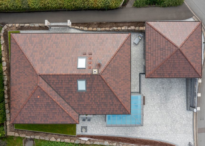 Zicht in vogelvlucht op schilddak met stylist in cottage.