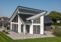 Tuinaanzicht van dakdetails van architectenwoning met lessenaarsdak en vlakke dakpan in edelnero