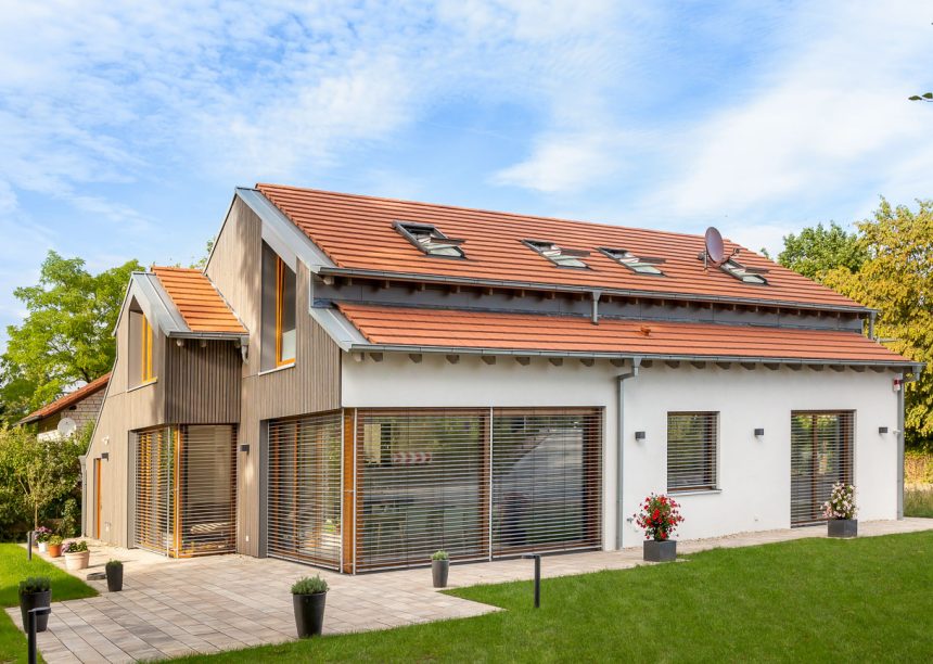 Trendy vrijstaand huis met Stylist vlakke dakpan in natuurrood op het dak
