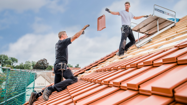 Dachdecker beim Eindecken eines Daches