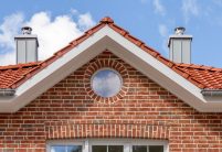 Sierlijke villa met bakstenen gevel/gemetseld met FD-dakpan en sierlijke nokvorst met details van de zadeldakkapel van het schilddak.