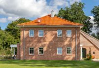 Anmutige Klinkervilla mit Flachdachziegel und Schmuckfirst mit harmonischer Farbabstimmung von Dach und Klinker.