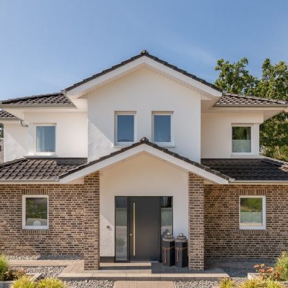 Kleine Stadtvilla mit Flachdachziegel J11v in altschwarz mit Eingangsbereich.