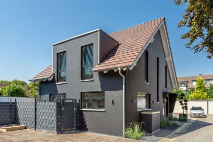 Traumhaus mit dunkler Fassade und Flachziegel in cottage in der Gesamtansicht
