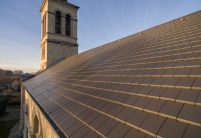 Historische kerk met minimalistische dakpan in edelschiefer vanuit vogelperspectief met zicht op het mooie dekbeeld.