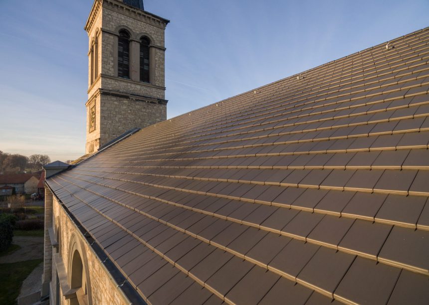Historische kerk met minimalistische dakpan in edelschiefer vanuit vogelperspectief met zicht op het mooie dekbeeld.