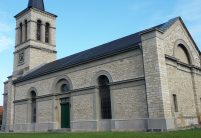 Historische kerk met minimalistische dakpan in edelschiefer vanuit vogelperspectief.