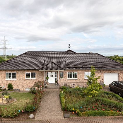 Stijlvolle bungalow met kastanjebruine dakpannen op het schilddak.