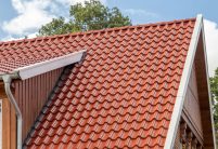 Dakzicht van een bakstenen huis met holle pan Z5 in toscana-rood mat gedekt.