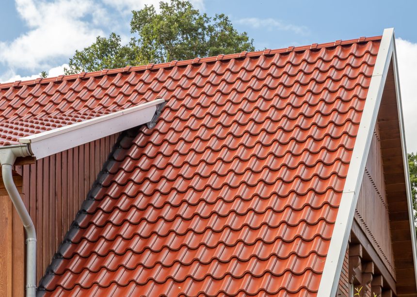 Dakzicht van een bakstenen huis met holle pan Z5 in toscana-rood mat gedekt.