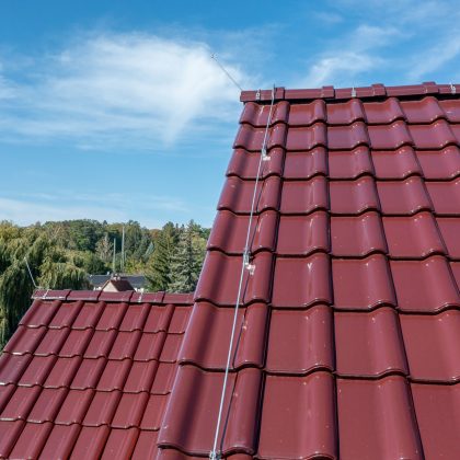 Mehrfamilienhaus mit J11v in edelweinrot hier mit Fokus auf den seitlichen Dachabschluss.