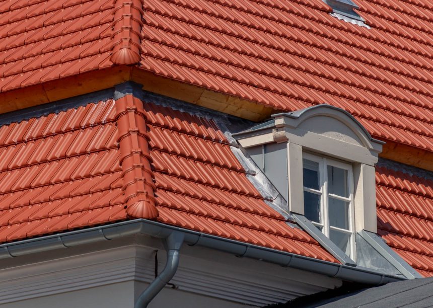 Tradition in rotbraun auf Mehrfamileinhaus mitten in der Stadt - der Dachziegel von Jacobi im Doppelmuldendesign. Im Bildfokus der  formschöne Gradanfänger in Muschelform aus dem keramischen Jacobi-Zubehör