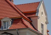 De dakpan Tradition in roodbruin op een appartementencomplex midden in de stad – de keramische dakpan van Jacobi met het karakteristieke dubbelholle profiel. Hier uitgevoerd in roodbruin.