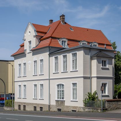 De dakpan Tradition in roodbruin op een stedelijk appartementencomplex – de keramische dakpan van Jacobi met het karakteristieke dubbelholle profiel. Hier uitgevoerd in roodbruin.