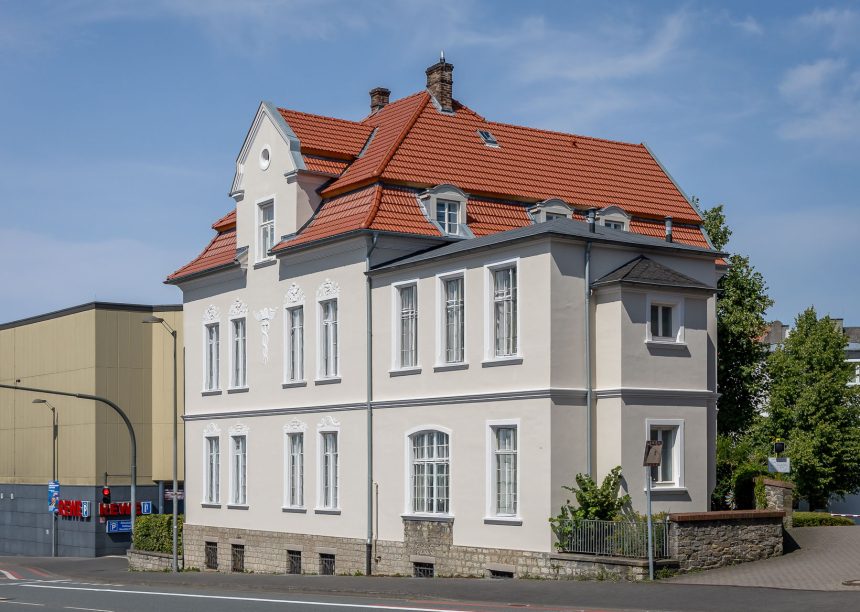 De dakpan Tradition in roodbruin op een stedelijk appartementencomplex – de keramische dakpan van Jacobi met het karakteristieke dubbelholle profiel. Hier uitgevoerd in roodbruin.