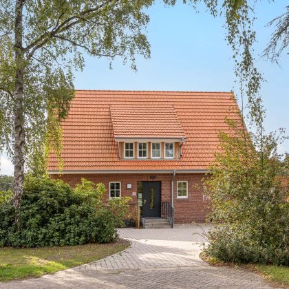 Frontaal gefotografeerd: jeugdcentrum met de keramische dakpan Dubbele Holle Dakpan Z2 in natuurrood, een gevel in metselbaksteen en een zadeldak.