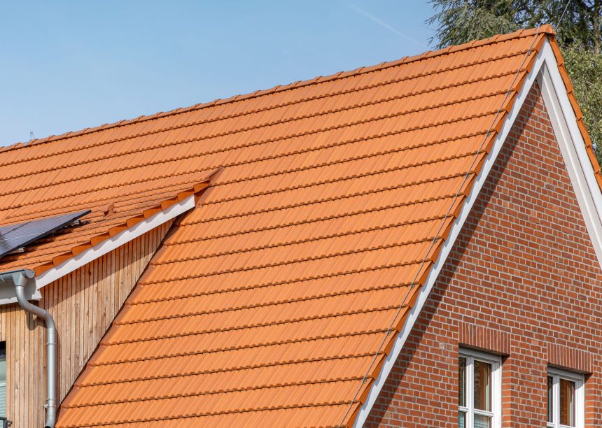 Geveltop van een jeugdcentrum met de keramische Dubbele Holle Dakpan Z2 in natuurrood. Op de foto staan de beginvorst, de linker- en rechtergevelpan en de bakstenen gevel centraal.