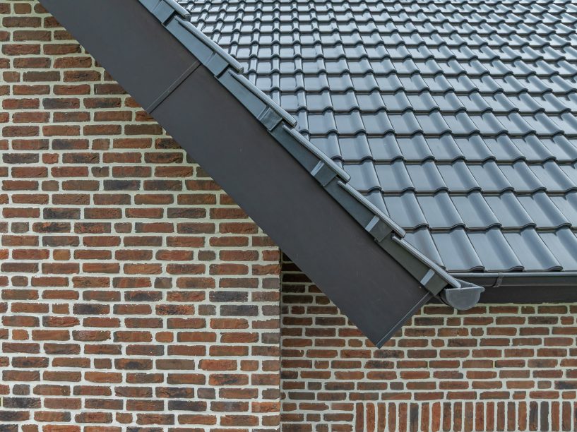 Inspirerende referentie voor bouwers en ontwerpers met J11v in spacegrijs op een zadeldak, met focus op de zijafwerking van het dak bij de gevelrand.