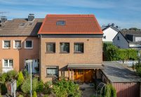 PV-oplossing met zonnepannen in roodbruin – volledig gefotografeerd met zicht op de tuin.