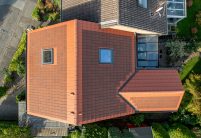 PV-oplossing met zonnepannen in roodbruin, vanuit vogelperspectief – twee-onder-een-kapwoning / rijwoning