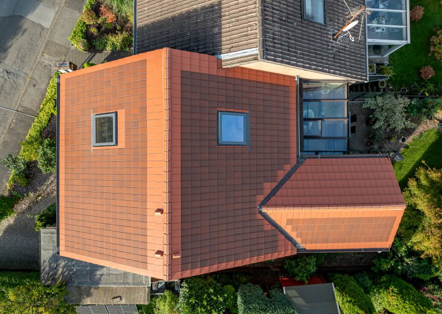PV-oplossing met zonnepannen in roodbruin, vanuit vogelperspectief – twee-onder-een-kapwoning / rijwoning