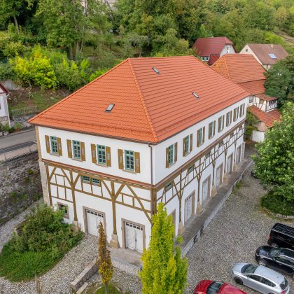 Tradition in natuurrood op een door Zipperlein Holzbau gerenoveerd vakwerkhuis, gefotografeerd vanuit een drone in totaaloverzicht